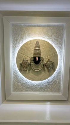 an art piece is displayed in the center of a white frame with light shining on it