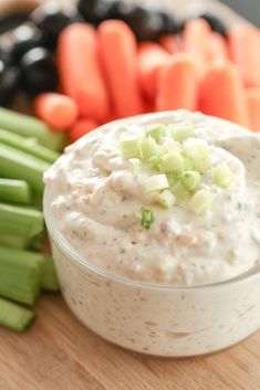 dip with celery and black olives on a cutting board