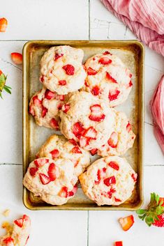 strawberry muffins in a tin with fresh strawberries on the side