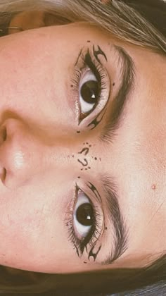 a close up of a person with eyeliners on her face and eyebrows, looking at the camera