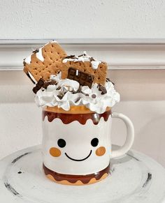 a coffee mug with whipped cream, chocolate chips and marshmallows in it