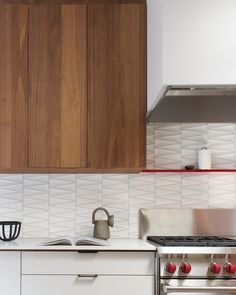 a stove top oven sitting inside of a kitchen next to a wooden cupboards and counter