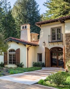 this is an image of a beautiful house in the woods with lots of trees and bushes