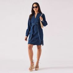 "Introducing our stunning Wrap V Neck Denim Dress in a charming Dark Blue Wash. This dress combines the timeless appeal of denim with a feminine wrap design, creating an effortlessly chic and versatile piece. The V-neckline adds a touch of allure, while the dark blue wash exudes sophistication. With its flattering silhouette and comfortable fit, this dress is perfect for any occasion - whether it's a casual lunch date or a night out on the town. Crafted with care and attention to detail, this stylish dress is a must-have addition to your wardrobe. Product Features: Dark blue wash Denim fabric Side Style belted waist adjuster Pullover style Regular fit Long Cuffed sleeves V-Neck Collar Hem slit detail Fabric: 100% Cotton Our Model is 5'9\" and Wears Size 8. To find the perfect fit for yours Chic Knee-length Washed Blue Denim Dress, Chic Washed Blue Knee-length Denim Dress, Chic Knee-length Indigo Dress, Chic Indigo Denim Dress, Chic Long Sleeve Denim Dress For Brunch, Chic Long Sleeve Denim Brunch Dress, Chic Medium Wash Denim Dress For Workwear, Chic Medium Wash Denim Dress For Work, Chic Indigo Cotton Denim Dress