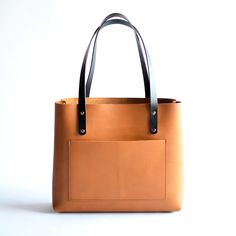 Leather tote bags are a classic accessory that stand the test of time. Our totes are versatile, practical, and classic, making them a must-have addition to any wardrobe. She's a versatile accessory that can be used for a range of purposes, from carrying your laptop to the office to carrying groceries...plus so much more! This bag is built to last!Honey LeatherBlack Leather StrapsBrass Hardware Top 10 Reasons Classic Leather Totes are Must-Haves ... • Fast & FREE Shipping on orders over $100• Mad Classic Square Satchel For On-the-go, Luxury Everyday Bags In Vegetable Tanned Leather, Classic Square Bucket Bag For Shopping, Classic Rectangular Bucket Bag For Shopping, Classic Tote Bag In Soft Leather, Vegetable Tanned Leather Bag For On-the-go, Rectangular Vegetable Tanned Leather Bags For Work, Classic Soft Leather Tote Bag, Classic Leather-lined Bucket Bag For Work