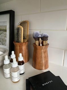 the bathroom counter is clean and ready to be used as a hairbrush holder, soap dispenser, and lotion bottles