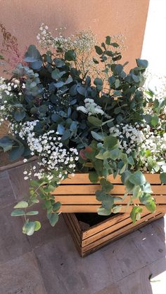 a planter filled with white flowers and greenery