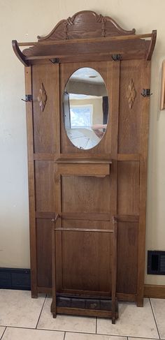 an old wooden armoire with a mirror on it