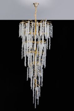 a chandelier with white beads hanging from it's center point on a black background