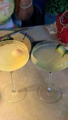 two martinis sitting next to each other on a table