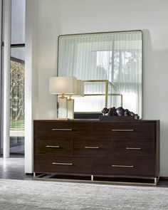 a dresser with a mirror and lamp on it