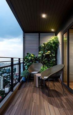 two chairs sitting on top of a wooden floor next to a plant filled balcony area