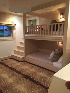 a bunk bed in the corner of a room with stairs leading up to another bedroom