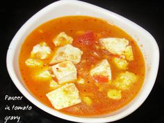 a white bowl filled with soup and tofu on top of a black countertop