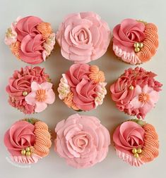 cupcakes with pink frosting and orange flowers on white background, top view