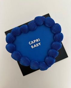 a blue frame with the words capri baby written in white on it and an image of a circle made out of spirals