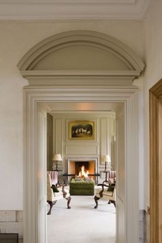 an open door leading to a living room with a fire place