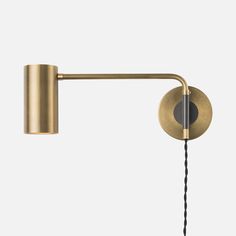 a gold wall light with a black cord attached to the arm and one bulb on each side