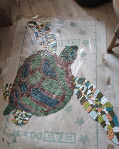 a turtle made out of mosaic tiles on the floor