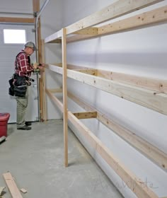 a man working on some shelves in a garage