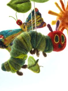 the very colorful caterpillar mobile is hanging from strings