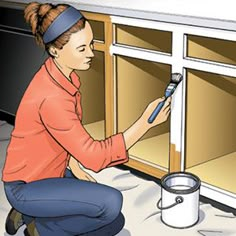 a woman is painting the inside of a cabinet