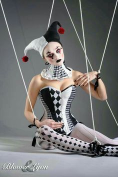 a woman dressed as a clown sitting on the ground