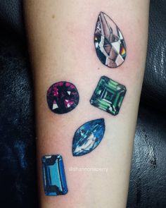 a tattoo with different colored stones on it