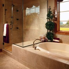 a bathroom with a large bathtub next to a window and a potted plant