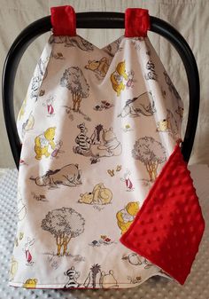 a winnie the pooh potty cover with red handles on a black ironing board