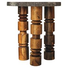 a wooden sculpture with three columns and a stone top on the bottom one column is made out of wood