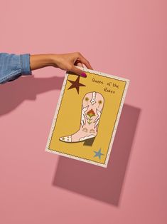 a person holding up a card with an image of a cowboy boot