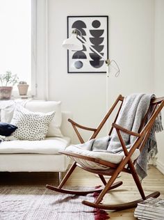 a rocking chair sitting in front of a white couch