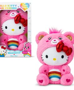 a pink hello kitty stuffed animal with a rainbow bow on its head next to a box