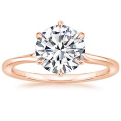 a rose gold engagement ring with a round diamond in the center