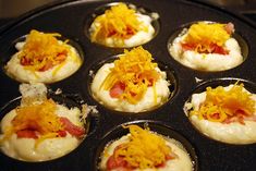 small appetizers with cheese and other toppings are in a muffin tin