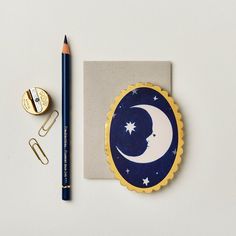 a notepad with a crescent and stars on it next to a pencil