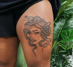 a woman with a snake tattoo on her thigh