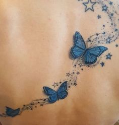 a woman's back with blue butterflies and stars on it