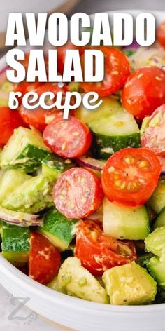 a bowl filled with cucumber, tomato and avocado salad on top of a table