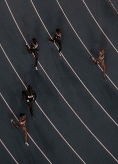 three women are running on the track with their hands in each other's pockets