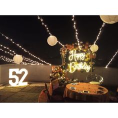 an outdoor birthday party with lights and decorations on the roof top, decorated for someone's 52th birthday