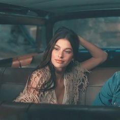 a man and woman sitting in the back of a car