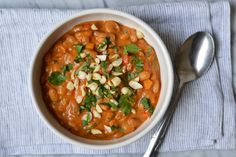 a white bowl filled with beans and cilantro on top of a blue towel