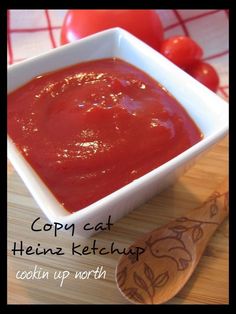 a white bowl filled with ketchup sitting on top of a wooden cutting board