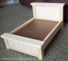 a wooden bed frame sitting on top of a carpeted floor