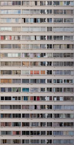 the side of an office building with many windows and balconies on each floor