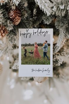 an ornament hanging from a christmas tree with family photos on it and pine cones in the background