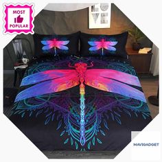 a bed covered in a black comforter with pink and blue dragonflies on it