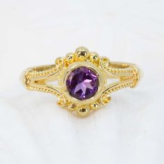 Unleash your inner classic beauty with this Amethyst Classical Ring, a luxurious 18K gold piece featuring intricate Etruscan granulation and a 6mm velvety purple amethyst. Enjoy wearing this gorgeous ring for any occasion. 18K gold ring features a row of granulation down each side as well as on the sides of the bezel. The elegant ring is set with a 6mm amethyst and a beveled lower band. Shown in a size 8, but each ring comes with free sizing and FREE SHIPPING! Unsure what ring size you are? It's Luxury Intricate Amethyst Jewelry, Luxury Yellow Gold Amethyst Ring With Bezel Setting, Luxury Gold Amethyst Ring With Bezel Setting, Luxury Gold Amethyst Promise Ring, Elegant Yellow Gold Amethyst Ring With Bezel Setting, Elegant Gold Amethyst Promise Ring, Elegant Purple Amethyst Bezel Setting Ring, Elegant Purple Amethyst Ring With Bezel Setting, Elegant Gold Amethyst Ring With Center Stone